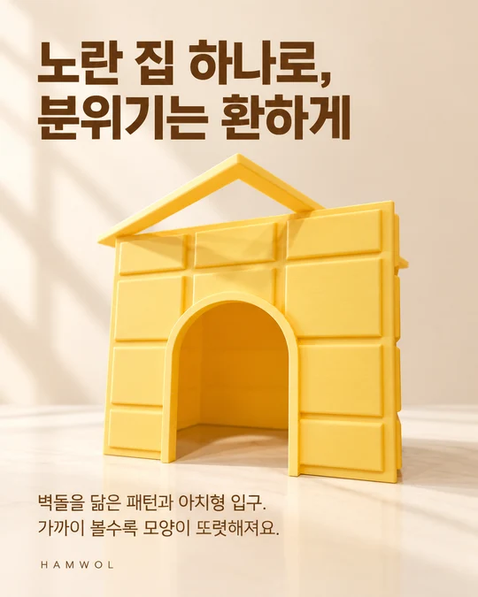 노란 집 하나로, 분위기는 환하게 — 벽돌을 닮은 패턴과 아치형 입구. 가까이 볼수록 모양이 또렷해져요.